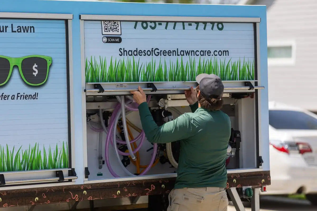 Technician preparing equipment in a Shades of Green service truck