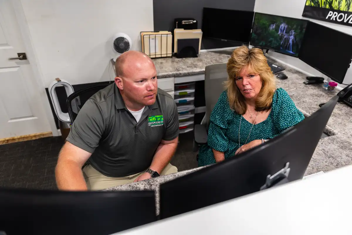 Two Shades of Green team members working together at an office computer
