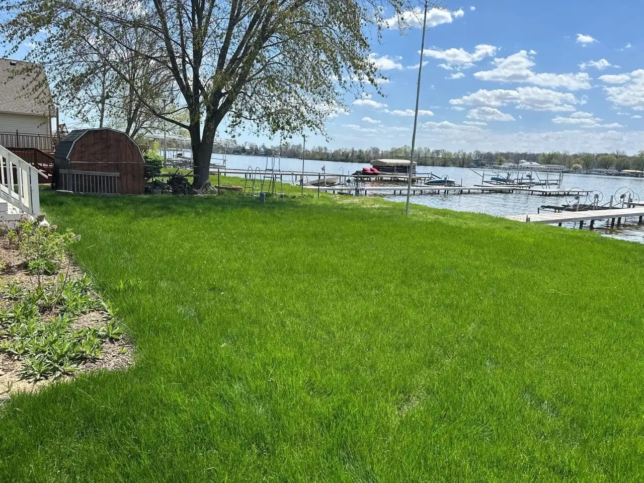 Green lakefront lawn with boat docks in Monticello, Indiana