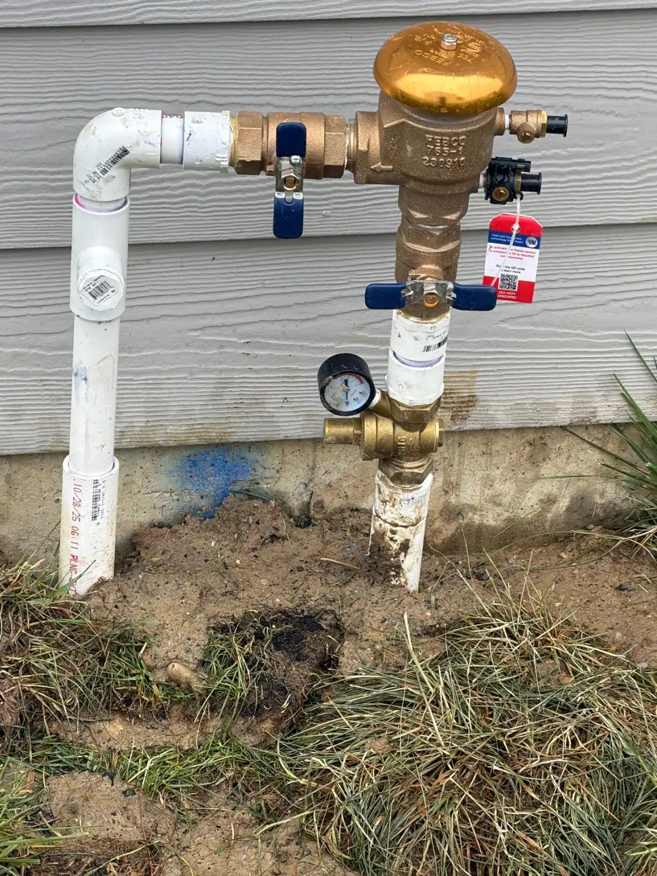 Backflow preventer with a test gauge on the sprinkler supply line outside a West Lafayette, Indiana home