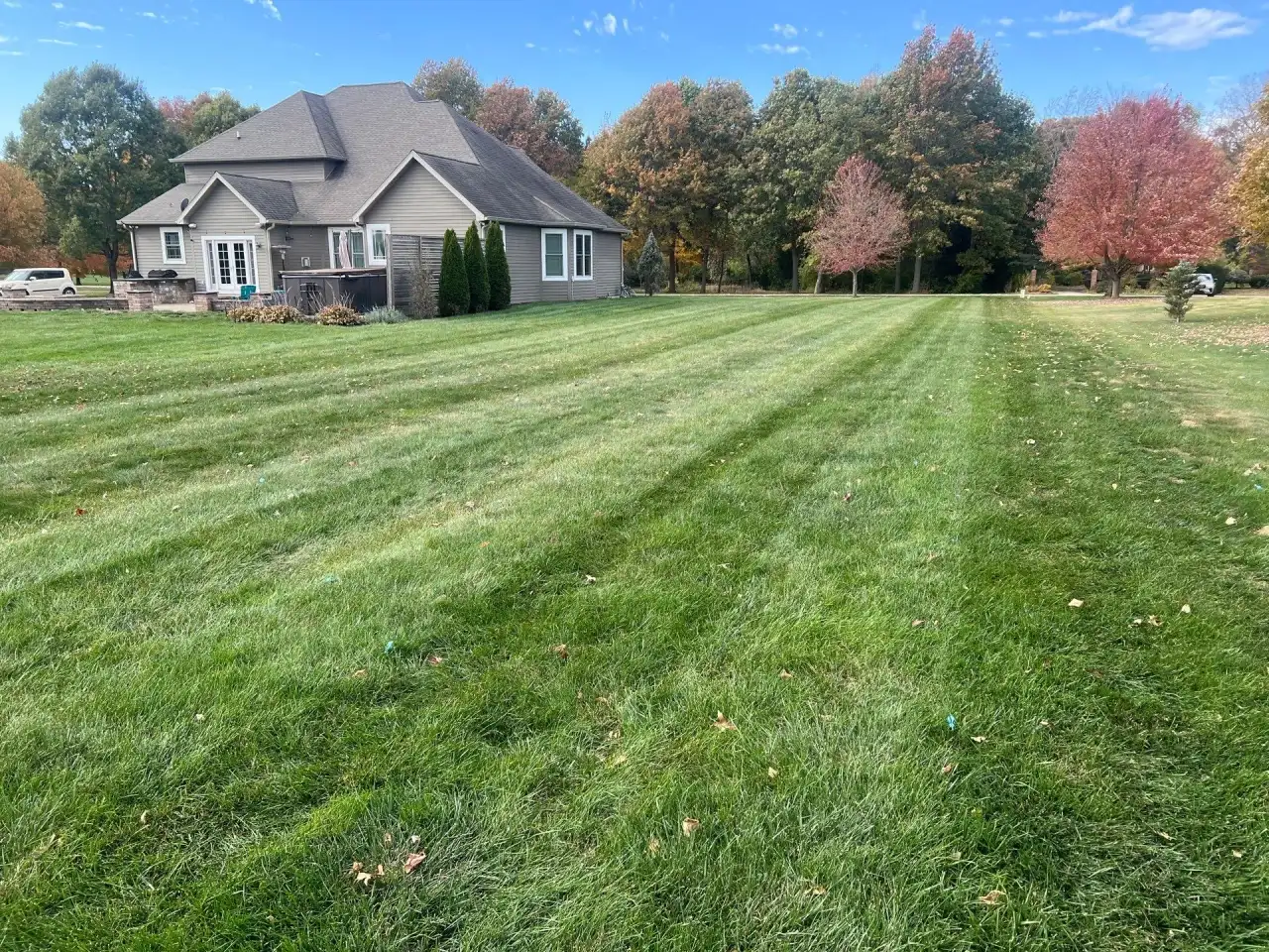 Striped back lawn and fall color behind a West Lafayette, Indiana home