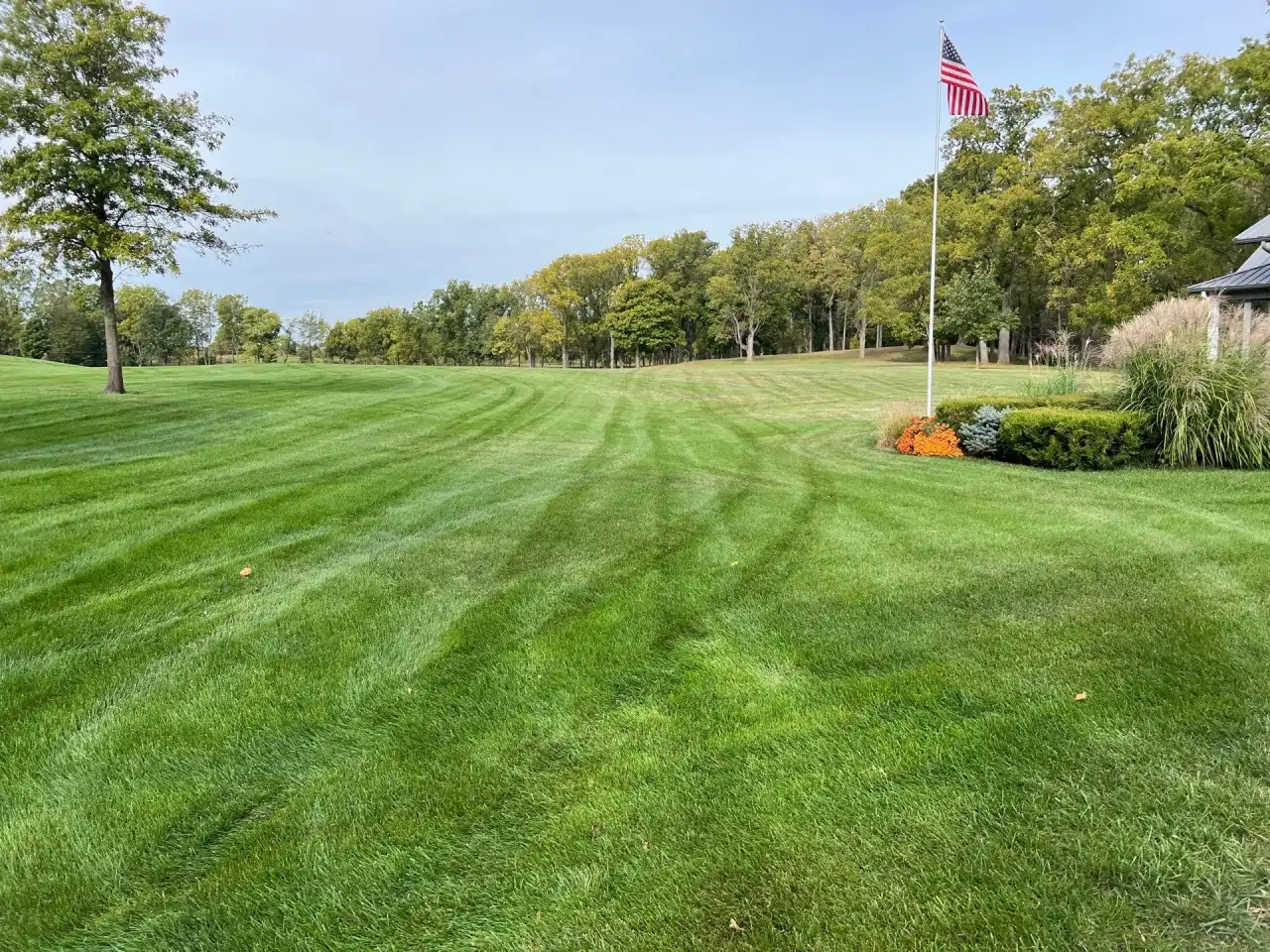 Striped lawn with an American flag and tree line in West Point, Indiana