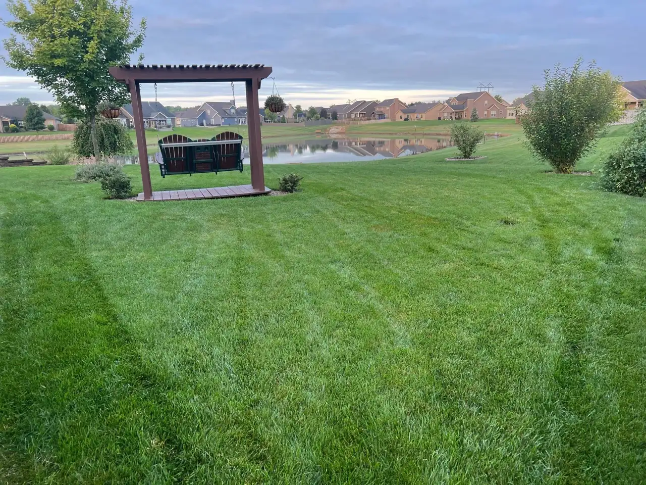 Striped lawn with a porch swing overlooking a pond in Lafayette, Indiana