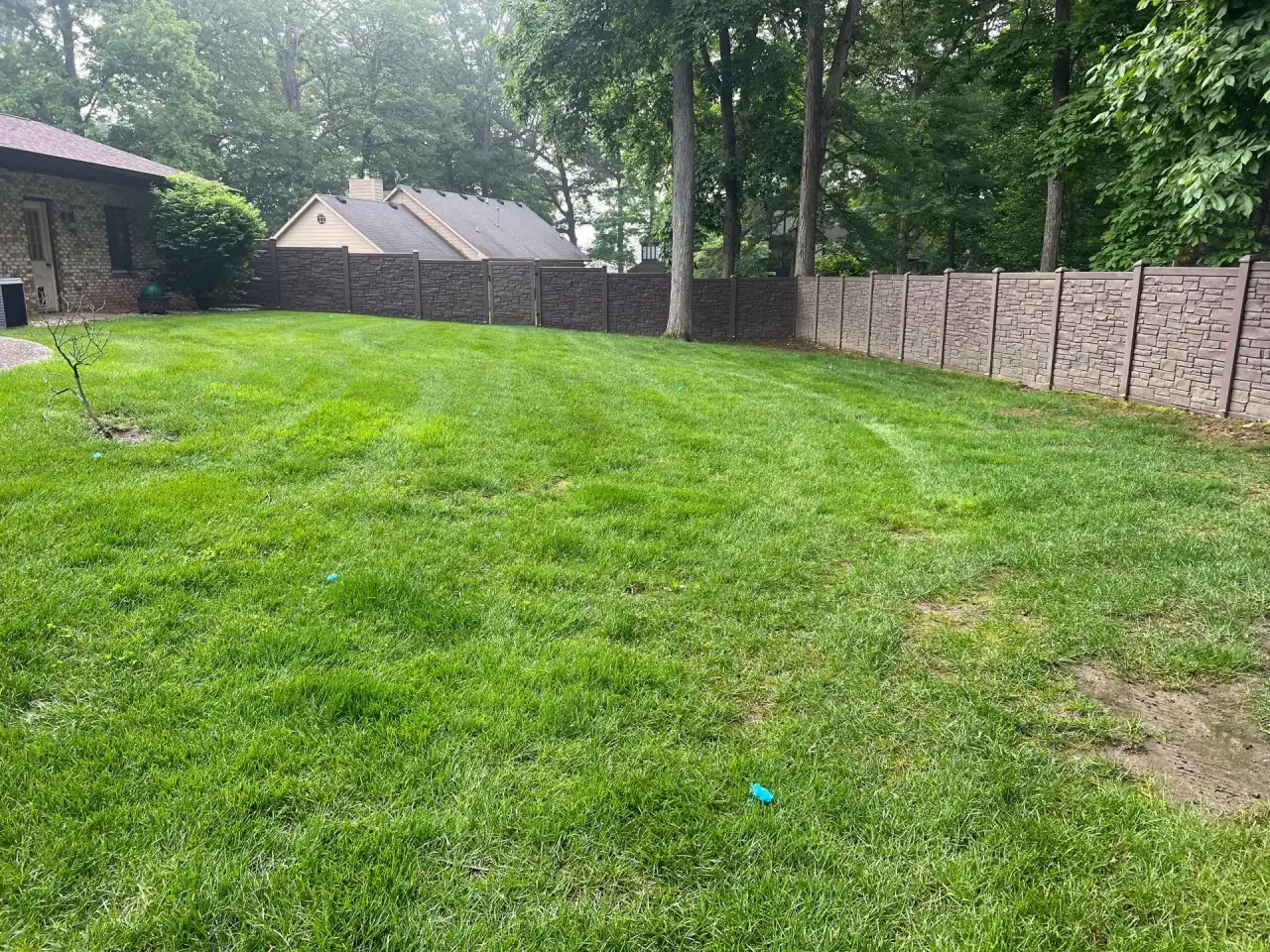 Wide lawn along a tall privacy fence in Williamsport, Indiana