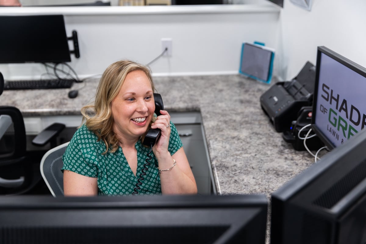 happy customer service rep speaking with a client on the phone