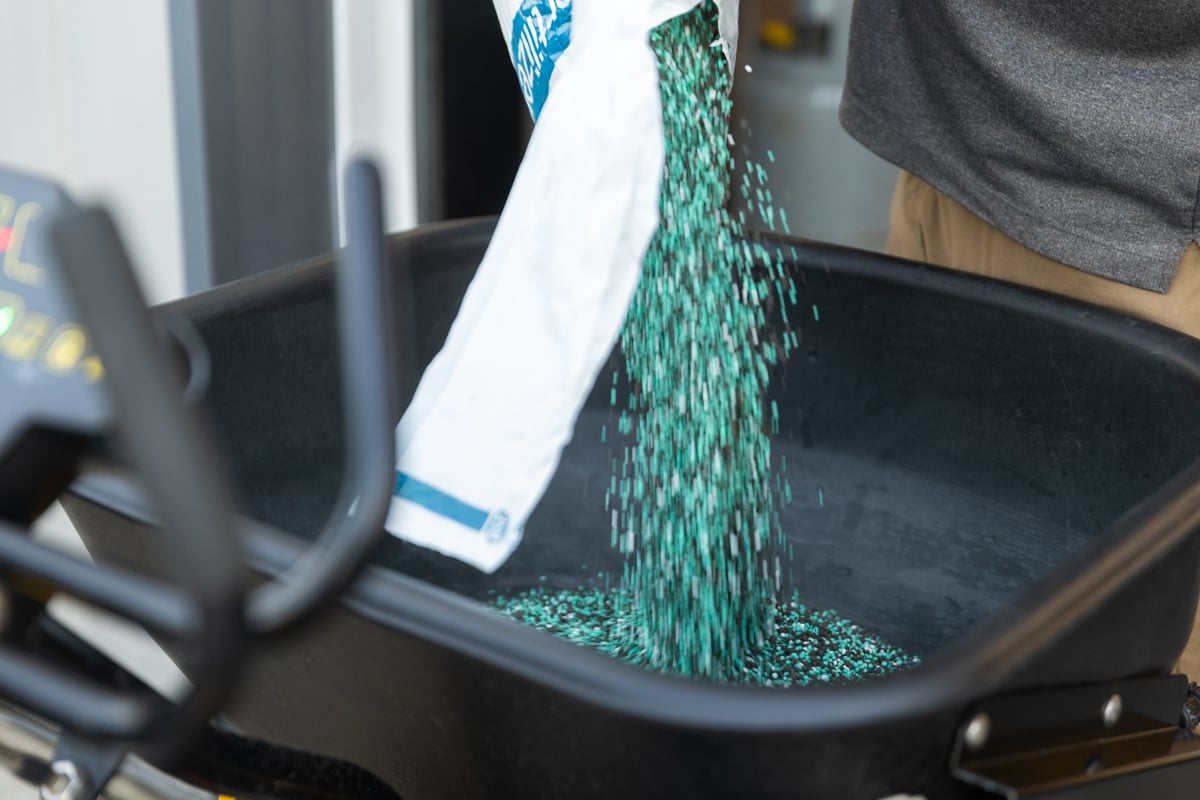 custom blended lawn care fertilizer being poured into a hopper